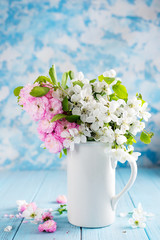 Lovely wild flowers bunch in ceramic vase on table in wooden background . Valentines or mother's day