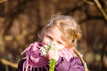 child with snowdrop flowers