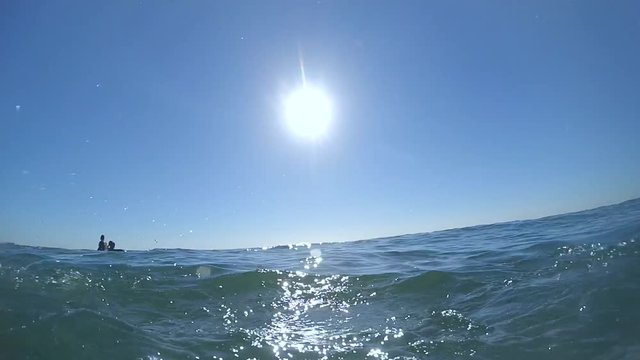 Slow motion. POV of a woman is swimming in the sea. The camera rises and descends to the water level sea ocean. Summer warm hot sunny day. Rest relax vacation holiday. Sport health lifestyle hobby