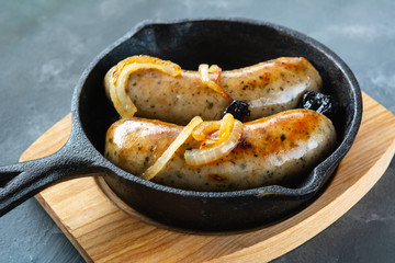 White sausage fried with onions and dried plums.