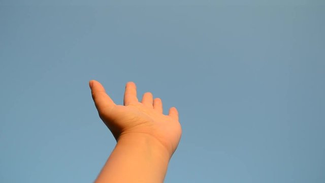 POV. Hand movement in the air background blue clear cloudless sky close-up. Motion of the wrist person of the Caucasian nationality at sunset dawn sunrise