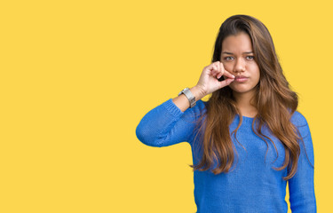 Young beautiful brunette woman wearing blue sweater over isolated background mouth and lips shut as...