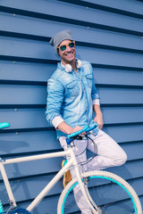 modern young guy with casual clothes, hat and glasses on bicycle - 241623224