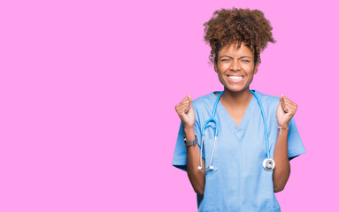Young african american doctor woman over isolated background excited for success with arms raised...