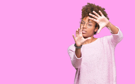 Beautiful young african american woman wearing glasses over isolated background Smiling doing frame using hands palms and fingers, camera perspective