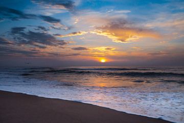 Naklejka na ściany i meble Sunset on the beach, beautiful ocean, colorful sky and flock of seagulls