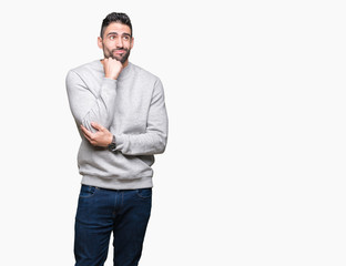 Fototapeta premium Young handsome man wearing sweatshirt over isolated background with hand on chin thinking about question, pensive expression. Smiling with thoughtful face. Doubt concept.