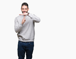 Young handsome man wearing sweatshirt over isolated background Doing time out gesture with hands,...