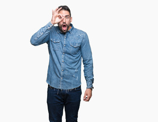 Fototapeta premium Young handsome man over isolated background doing ok gesture shocked with surprised face, eye looking through fingers. Unbelieving expression.