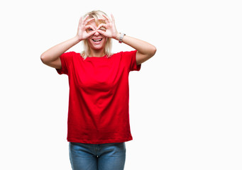 Young beautiful blonde woman wearing red t-shirt over isolated background doing ok gesture like binoculars sticking tongue out, eyes looking through fingers. Crazy expression.