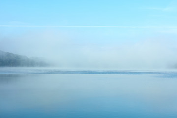 Morning fog on the lake on a summer day