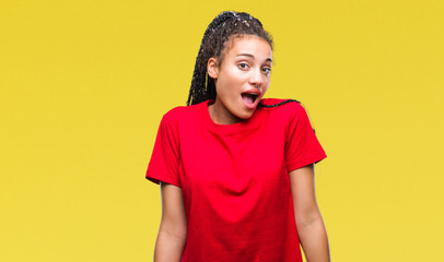Young braided hair african american girl over isolated background afraid and shocked with surprise...
