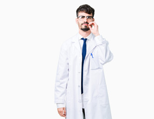 Young professional scientist man wearing white coat over isolated background mouth and lips shut as...