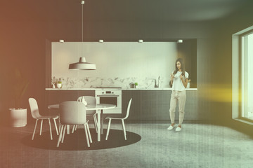Gray and white kitchen with table, woman