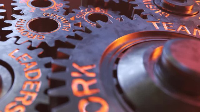 Closeup on working metallic gears with glowy terms connected to the business.