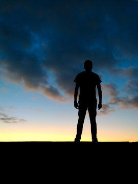 Homme se tenant avec d&eacute;termination face au coucher de soleil