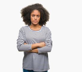 Young afro american woman over isolated background skeptic and nervous, disapproving expression on face with crossed arms. Negative person.