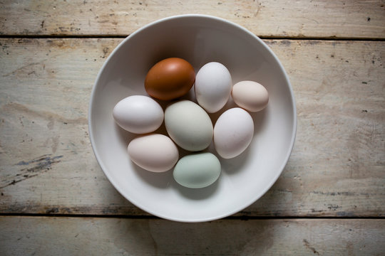 Overhead view of eggs in bowl on wooden table