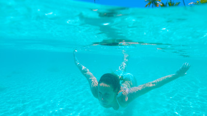 HALF HALF: Happy woman diving by the paradise island in the turquoise ocean