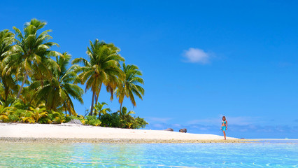 Obraz premium LOW ANGLE: Young girl in bikini going for a scenic walk down the sandy beach.