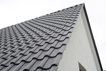 ziegeldach Dachdecken beim Hausbau in der Stadt, schwarze Dachziegel vom Dachdecker