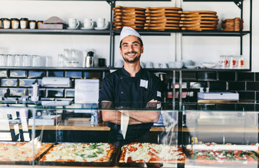 Portrait of smiling chef standing in pizzeria