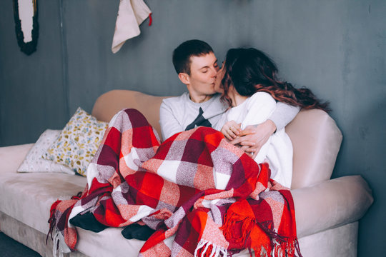 Couple in love sitting on the sofa at home kissing