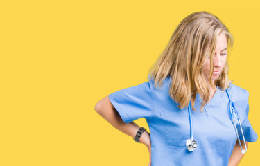 Beautiful young doctor woman wearing medical uniform over isolated background Suffering of backache, touching back with hand, muscular pain