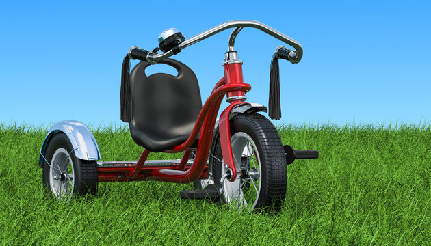Children's tricycle on the green grass against blue sky, 3D rendering