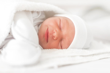 Sleepy baby girl close-up in a baby cot.