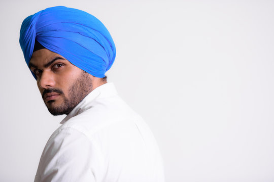 Face Of Young Bearded Indian Sikh Man Wearing Turban And Looking Back
