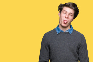 Fototapeta premium Young handsome elegant man over isolated background sticking tongue out happy with funny expression. Emotion concept.