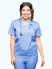 Young adult doctor woman wearing medical uniform with a happy and cool smile on face. Lucky person.