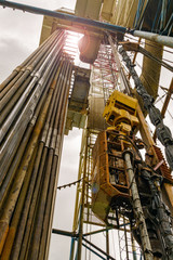 Oil and Gas Drilling Rig onshore dessert with dramatic cloudscape. Oil drilling rig operation on the oil platform in oil and gas industry. Land oil drilling rig blue sky