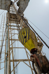 Fototapeta premium Oil and Gas Drilling Rig onshore dessert with dramatic cloudscape. Oil drilling rig operation on the oil platform in oil and gas industry. Land oil drilling rig blue sky