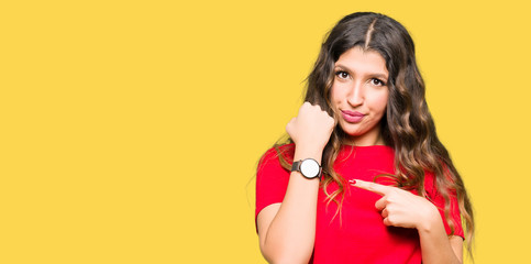 Young beautiful woman wearing casual t-shirt In hurry pointing to watch time, impatience, upset and angry for deadline delay