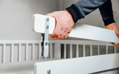 Construction of bed for children. Putting a protective railing on the bed. Role of the father in...