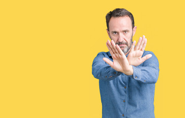 Handsome middle age elegant senior man over isolated background Rejection expression crossing arms...