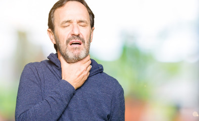Naklejka premium Middle age handsome man wearing a sweater Touching painful neck, sore throat for flu, clod and infection