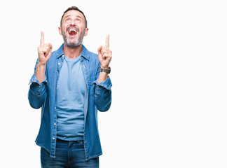 Fototapeta premium Middle age hoary senior man over isolated background amazed and surprised looking up and pointing with fingers and raised arms.