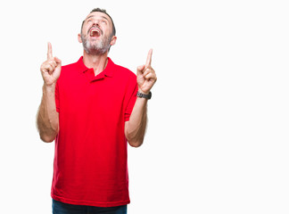 Middle age hoary senior man over isolated background amazed and surprised looking up and pointing with fingers and raised arms.