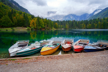 Lago di Fusine the mountain lake at boat and Mangart mountain in the background in north Italy