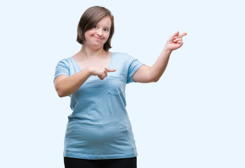 Young adult woman with down syndrome over isolated background smiling and looking at the camera pointing with two hands and fingers to the side.