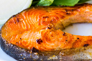 The salmon fish served with salat on the plate