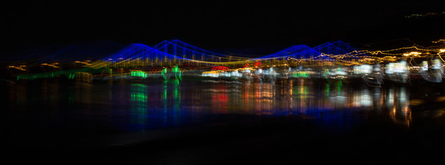 Abstract cityscape with a bridge over the river and multi-colored lights