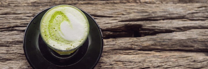 Cup of matcha latte against the old wooden table BANNER, LONG FORMAT