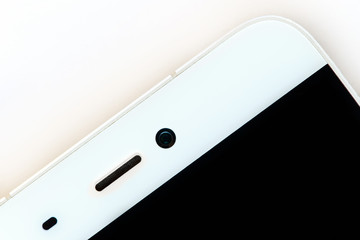 top view of the speaker and front camera of a white smartphone, macro