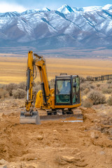 Obraz premium Tractor in front of wonderful mountains behind