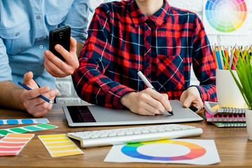 Your young designer discussing ideas and smiling while working in office