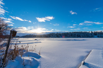 Sun Shining On Fresh Snowfall Over Frozen Lake